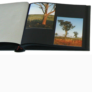 Open small black linen photo album showing alternate layouts with 10x15cm photos from The Photo Album Shop